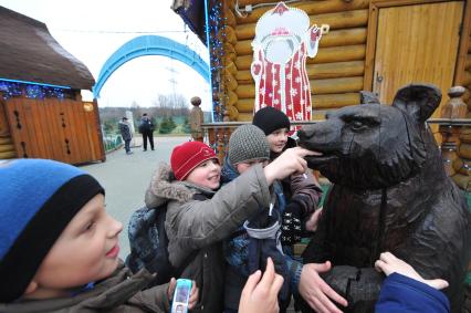 Усадьба Деда Мороза. На снимке: дети и деревянный мишка. 09 декабря  2011 года.