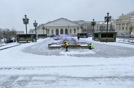 Жанровая фотография. Зима в городе. На снимке:  дворники убирают снег на Манежной площади. Москва. 21 декабря  2011 года.