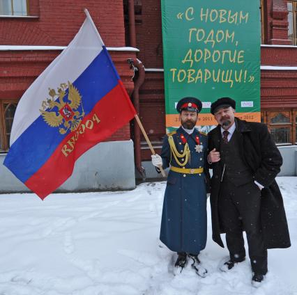 Жанровая фотография. Мужчины в образе В.И.Ленина и царя Николая второго стоят на фоне плаката С НОВЫМ ГОДОМ, ДОРОГИЕ ТОВАРИЩИ!. Москва. 21 декабря  2011 года.