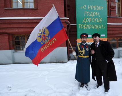 Жанровая фотография. Мужчины в образе В.И.Ленина и царя Николая второго стоят на фоне плаката С НОВЫМ ГОДОМ, ДОРОГИЕ ТОВАРИЩИ!. Москва. 21 декабря  2011 года.