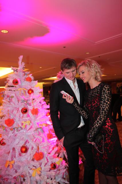 Церемония FASHION NEW YEAR 2012. На снимке  телеведущая Ольга Бузова с женихом, футболистом Дмитрием Тарасовым. 12 декабря 2011 года.