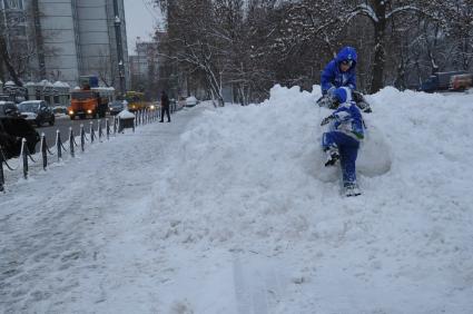 Зима в городе. На снимке: дети играют на снежном сугробе. 22 декабря  2011 года.