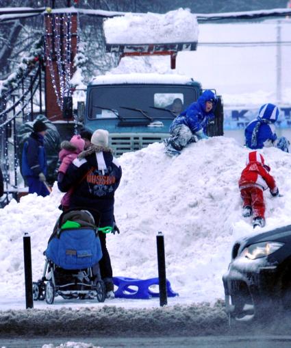 Зима в городе. На снимке: дети играют на снежном сугробе. 22 декабря  2011 года.