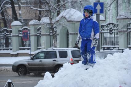 Зима в городе. На снимке: ребенок стоит на снежном сугробе. 22 декабря  2011 года.