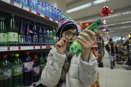 Покупатель в магазине изучает товары сквозь лупу, 12 января 2012 года