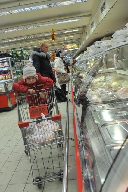 Женщина с ребенком в супермаркете выбирают продукты, 12 января  2012  года