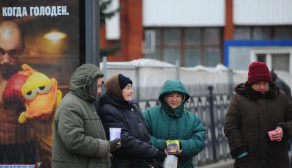 Бабки просят милостыню на автобусной остановке с надписью \"Когда голоден\", Москва, 30 ноября  2011  года