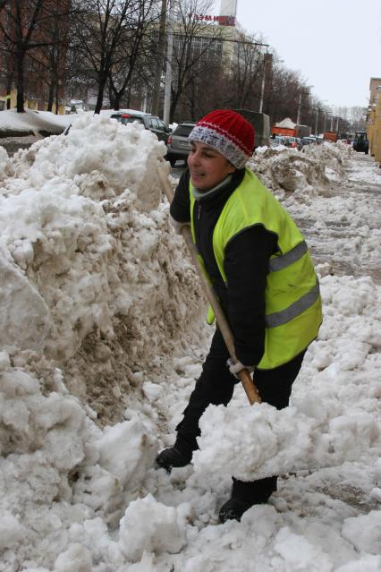 Женщина дворник расчищает улицы от сугробов. Уфа. 17 марта 2011 года.