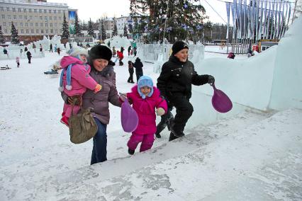 Дети с родителями собираются кататься на ледяной горке. В руках ледянки. 26 декабря 2011 года.