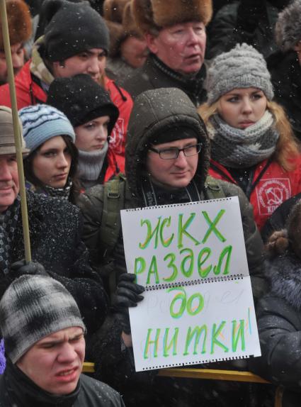 Во время митинга КПРФ  ЗА ДОСТОЙНУЮ ЖИЗНЬ И ЧЕСТНЫЕ ВЫБОРЫ  на Манежной площади. На снимке: мужчина с плакатом ЖКХ РАЗДЕЛ ДО НИТКИ. 21 января 2012 года.