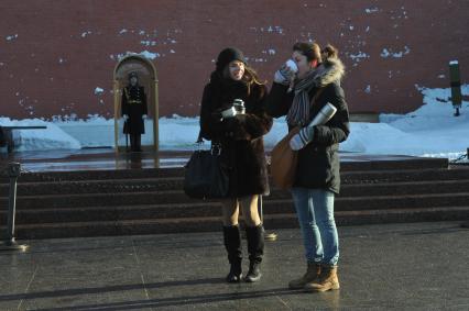 Зима. Прогулка в морозную погоду. На снимке: девушки пьют чай у Кремлевской стены. 24 января 2012 года.