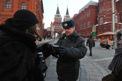 Зима. Девушка наливает полицейскому горячий чай из термоса в морозную погоду. 24 января 2012 года.