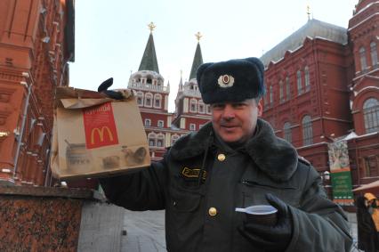 Зима. Полицейский держит в руках горячий чай и фирменный пакет Макдональдс. 24 января 2012 года.