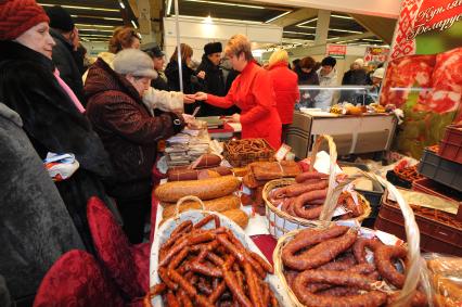 Торговля. Ярмарка. Белорусский мясопродукт. Продавец мясной лавки.  Покупатели. 25 января 2012 года