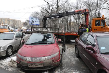 Сотрудники коммунальных служб города убирают на эвакуатор автомобиль \"Хонда\" (Honda) . Москва. 29 января 2009 года.