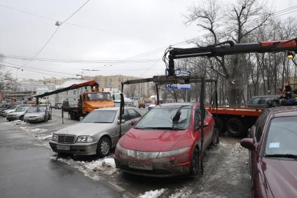 Сотрудники коммунальных служб города убирают на эвакуатор автомобиль \"Хонда\" (Honda) . Москва. 29 января 2009 года.