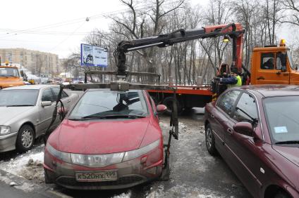 Сотрудники коммунальных служб города убирают на эвакуатор автомобиль \"Хонда\" (Honda) . Москва. 29 января 2009 года.