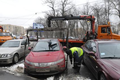 Сотрудники коммунальных служб города убирают на эвакуатор автомобиль \"Хонда\" (Honda) . Москва. 29 января 2009 года.