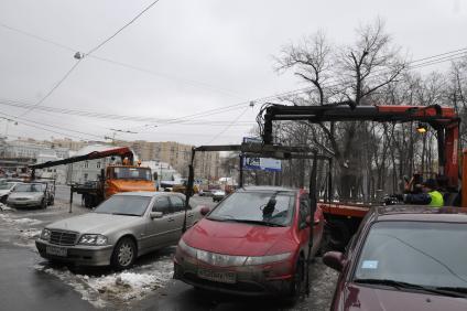 Сотрудники коммунальных служб города убирают на эвакуатор автомобиль \"Хонда\" (Honda) . Москва. 29 января 2009 года.