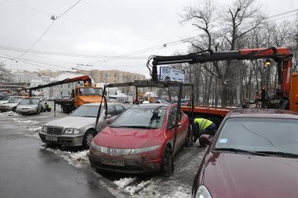 Сотрудники коммунальных служб города убирают на эвакуатор автомобиль \"Хонда\" (Honda) . Москва. 29 января 2009 года.
