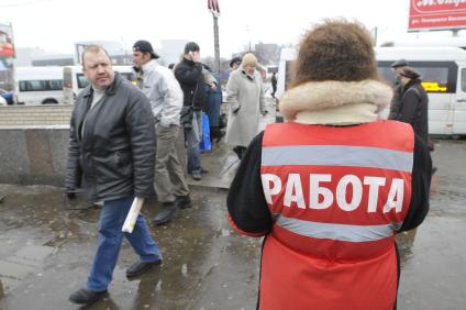 Женщина на улице распространяет бесплатную газету по трудоустройству \"Работай рядом с домом\". Москва. 10 февраля 2009 года.