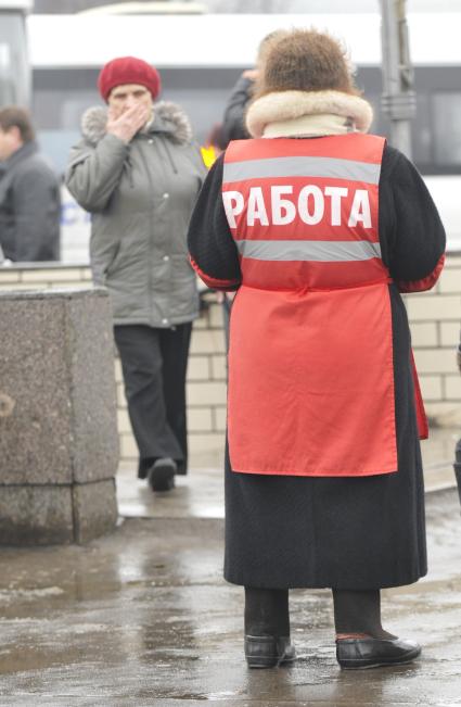 Женщина на улице распространяет бесплатную газету по трудоустройству \"Работай рядом с домом\". Москва. 10 февраля 2009 года.