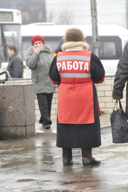 Женщина на улице распространяет бесплатную газету по трудоустройству \"Работай рядом с домом\". Москва. 10 февраля 2009 года.