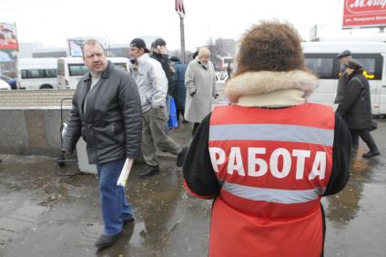Женщина на улице распространяет бесплатную газету по трудоустройству \"Работай рядом с домом\". Москва. 10 февраля 2009 года.