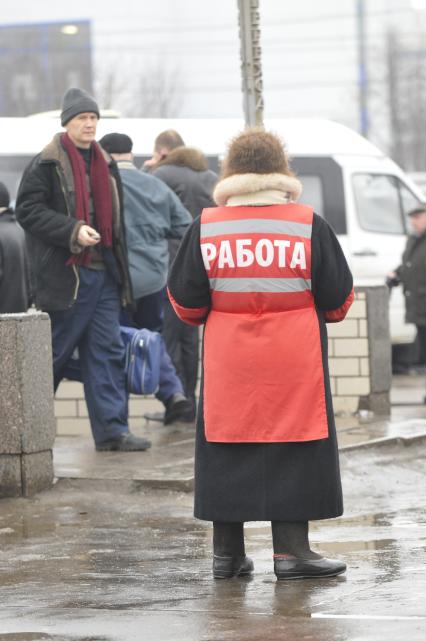 Женщина на улице распространяет бесплатную газету по трудоустройству \"Работай рядом с домом\". Москва. 10 февраля 2009 года.