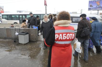 Женщина на улице распространяет бесплатную газету по трудоустройству \"Работай рядом с домом\". Москва. 10 февраля 2009 года.
