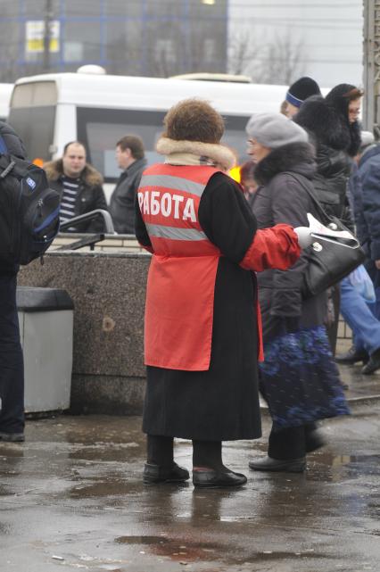 Женщина на улице распространяет бесплатную газету по трудоустройству \"Работай рядом с домом\". Москва. 10 февраля 2009 года.
