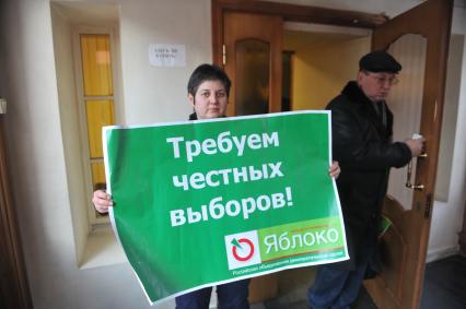 Женщина держит плакат пратии ЯБЛОКО с надписью ТРЕБУЕМ ЧЕСТНЫХ ВЫБОРОВ!. 27 января 2012 года.