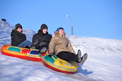 Зима. Зимние каникулы. Подростки катятся с горки на ватрушке. 29 января 2012