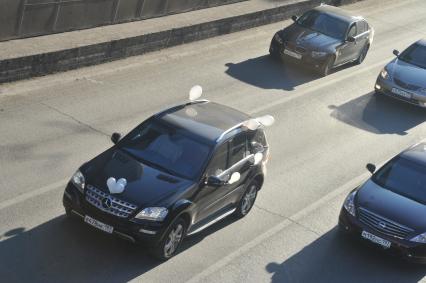 В Москве на Садовом кольце прошел автопробег  ЗА ЧЕСТНЫЕ ВЫБОРЫ. На снимке: машина с белыми воздушными  шарами. 29 января 2012