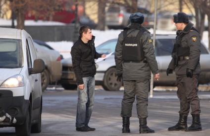 Двое сотрудников полиции помогают водителю найти нужный адрес.