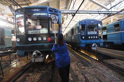 Электродепо метрополитена. Женщина моет вагон электропоезда метро.