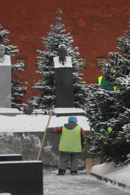 Кремлевская стена. Некрополь в Александровском саду. На снимке дворник убирает снег.