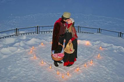Аниматоры Ромео и Джульетта стоят в центре композиции из свечей в форме сердца.