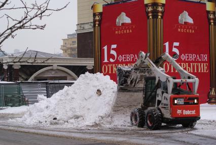 Снегоуборочная техника. Мини-экскаватор и большая куча снега. Сугроб.