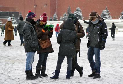 Иностранные туристы на Красной площади изучают путеводитель.