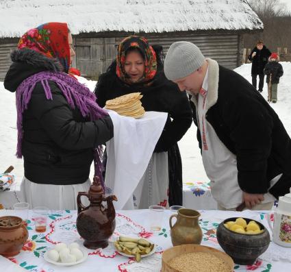 Две женщины и мужчина стоят у праздничного стола, во время празднования масленичной недели. Деревня Озерцо/Минская область.