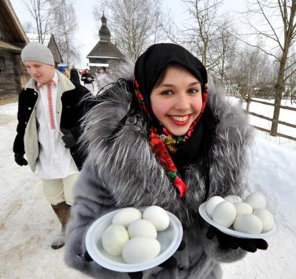 Девушка с тарелками яи идет по деревне. Деревня Озерцо/Минская область.