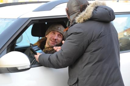 Водитель автомобиля проверяет себя на наличие алкоголя в крови.