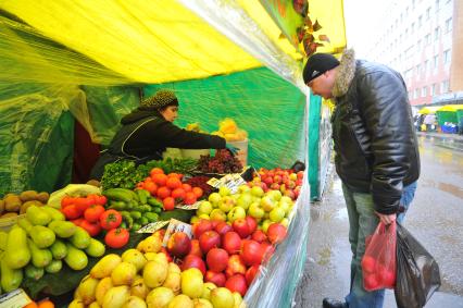 Ярмарка выходного дня. На снимке:  продавец овощной палатки