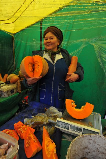 Ярмарка выходного дня. На снимке:  продавец овощной палатки.