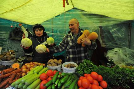 Ярмарка выходного дня. На снимке:  продавец овощной палатки.