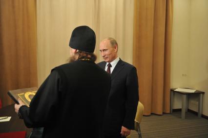 Игумен Никон из Свято-Успенского мужского монастыря `Саровская пустынь` и председатель правительства России Владимир Путин (справа) во время встречи в Доме ученых города Сарова.