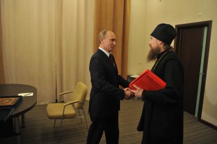Председатель правительства России Владимир Путин (слева) и игумен Никон из Свято-Успенского мужского монастыря `Саровская пустынь`во время встречи в Доме ученых города Сарова.