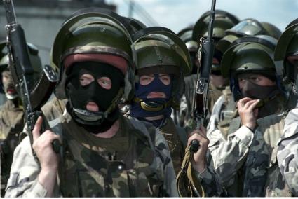 Тренировка войск особого назначения.
Солдаты в масках стоят держа оружие вверх.