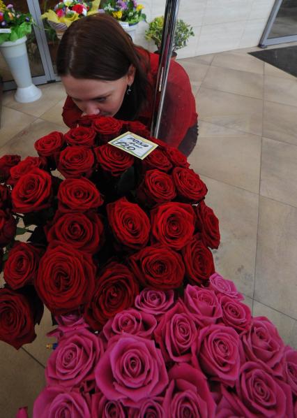 Цветочный магазин. На снимке: женщина и розы.